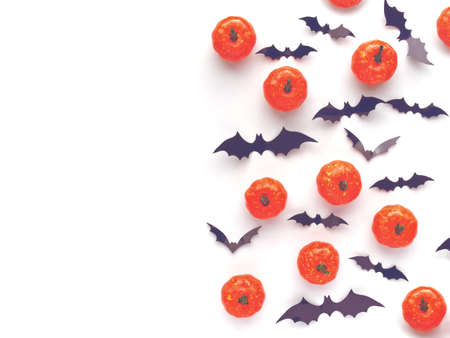 Little pumpkins and bat figures isolated on white background. The bed is a paper shopping bag. There...