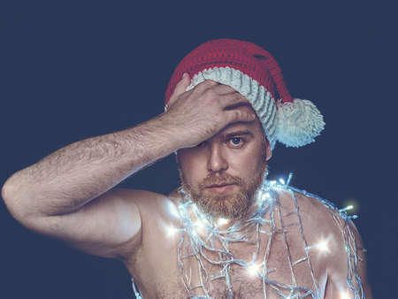 Santa Claus Naked Bearded Shirt There is a thoughtful expression on his face. On his naked body is a...