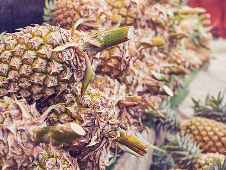 Fruits of Thailand. Ripe pineapples are on the counter of one of the many stalls located on the...