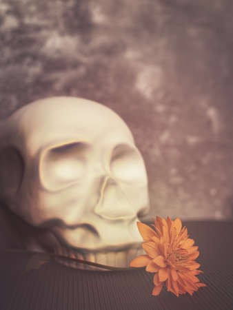 A yellow flower and decorative figure in the form of human skull. Gray cement background with scuffs and cracks.の写真素材