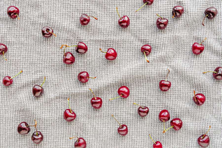 Berry composition. Ripe sweet cherries are on a gray waffle towel. Summer layout about nutrition.の写真素材