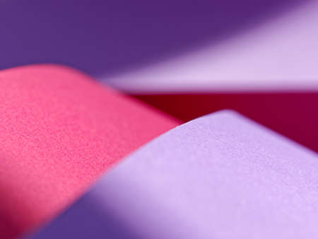 Abstract background made of red and purple sheets of thick paper twisted together. Shallow depth of...