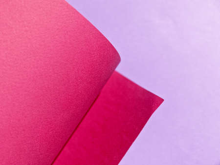 Abstract background made of red and purple sheets of thick paper twisted together. Shallow depth of...