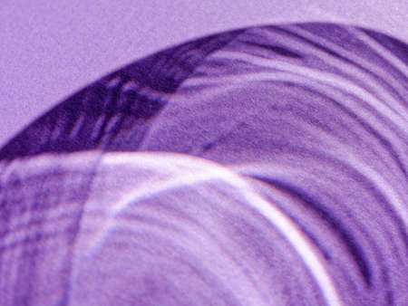 Abstract background made by rays of light refracted through a glass goblet on textured colored...
