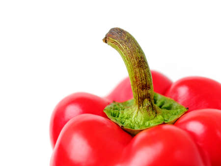 Ripe red bell pepper with a green dried stalk is isolated on a white background. Ingredient for salad, roast, soup and many other recipes.の写真素材
