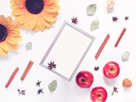 Autumn composition. Template made from empty metal photo frame, dried leaves, flowers and ripe red apples. Top view. Copy space.の写真素材