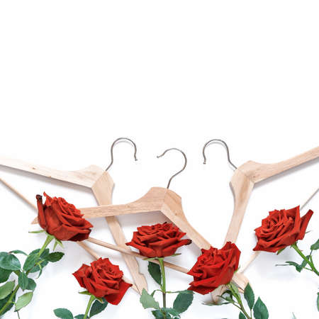 Wooden hangers and red roses are on a white background. Template for banner sales, discounts,...