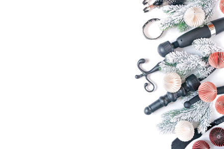 Various sex toys, fir branches with snow, paper Christmas balls are on a white background....