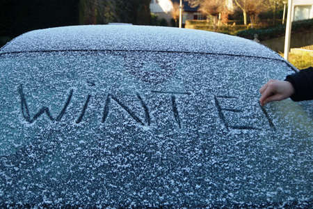Writing the word 'winter' on a car windowの写真素材