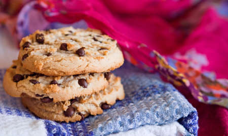 Oatmeal cookies with chocolate chips stacked on a white, blue, pink background. Selective focusの写真素材