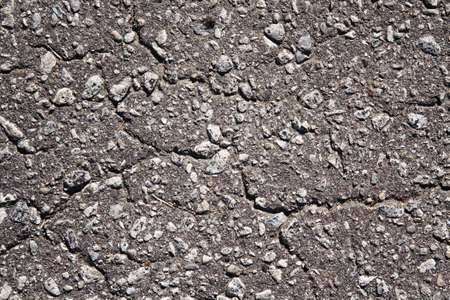 Textured gray pavement with pebbles, waves and curves backgroundの写真素材