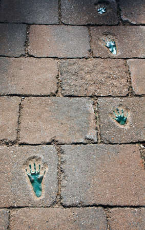 Brick cobble pavement with green footprints of an alienの写真素材