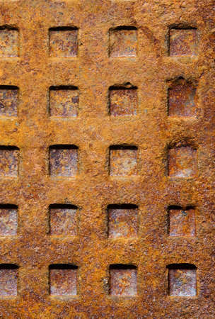 Old dirty rusty sewer manhole rough surface texture background with square patternの写真素材