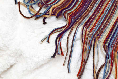 Colorful wool scarf on a white sheep fur, background texture wallpaper, natural ecological organic clean cover, Christmas winter card, copy space for textの写真素材