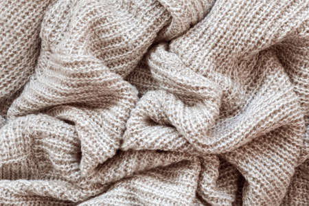 Closeup macro texture of knitted wool fabric, clothing background with wrinkles and folds
