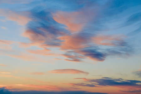 Beautiful pink, red, yellow sun beams clouds on a dark light blue sky on a sunset sunrise,...
