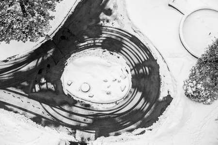 Black and white view from above of winter scene with trees, car traces and steps on snow, multiple circle shapes, graphic contrast designの写真素材