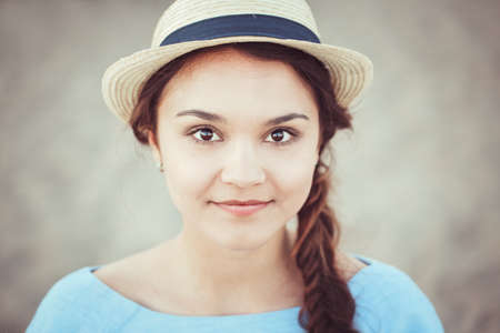 Closeup portrait of beautiful smiling white Caucasian brunette girl with brown eyes and plait, in...