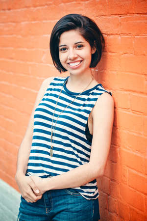 Portrait of beautiful smiling young hipster latin hispanic girl woman with short hair bob, in blue...