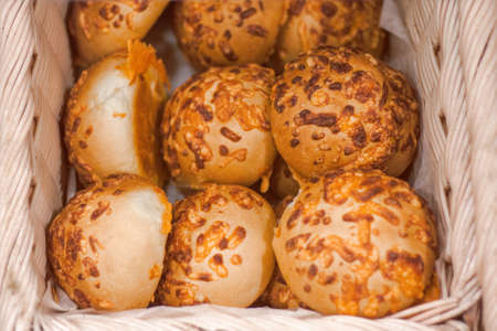 Closeup macro shot of round fresh cheese buns in basket with white paperの写真素材