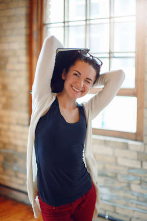 Portrait of happy smiling beautiful white Caucasian young brunette woman student, female drawing designer artist, in hall of college university, person at work, hobby activity conceptの写真素材