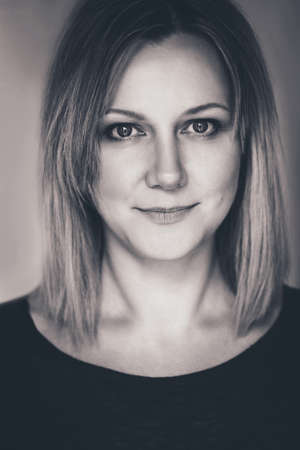 Closeup black-and-white portrait of beautiful young middle age Caucasian woman looking in camera. Woman with long blonde hair bob, flirty lookの写真素材