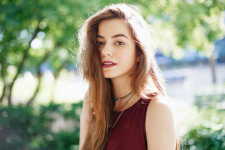 Portrait of smiling innocent Caucasian middle eastern blonde young beautiful woman with long hair and brown eyes, looking in camera. Girl with with natural beauty emotions outside on summer day.の写真素材