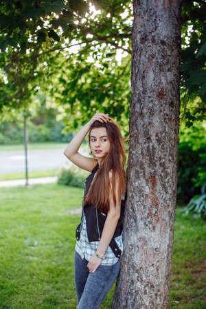 Portrait of pensive young middle eastern Caucasian jewish woman with long dark hair and black brown eyes looking away. Beautiful girl in park outside at sunset. Natural beautyの写真素材