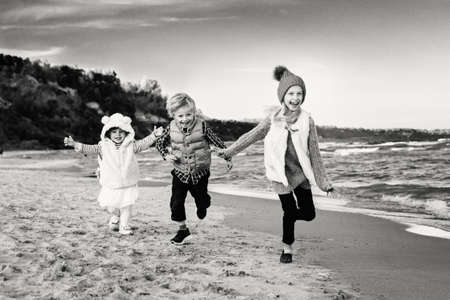 Group black and white portrait of three funny smiling laughing Caucasian children kids friends...