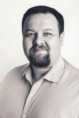 Close-up black and white portrait of Caucasian  business man with blue eyes looking directly in...