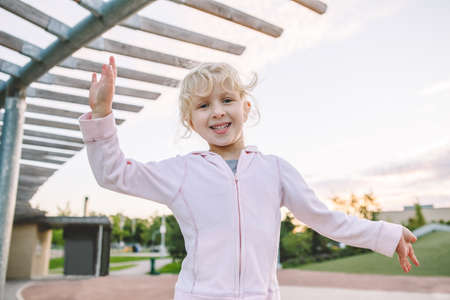 Happy childhood. Portrait of cute adorable little blonde Caucasian girl child making funny silly...