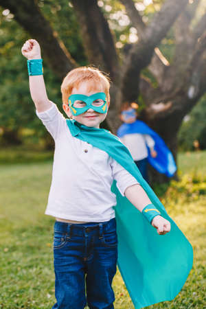 Cute adorable preschool Caucasian child playing superhero in costume. Boy kid wearing green mask and cape having fun outdoors in park. Happy active childhood. Power and protection concept.の写真素材