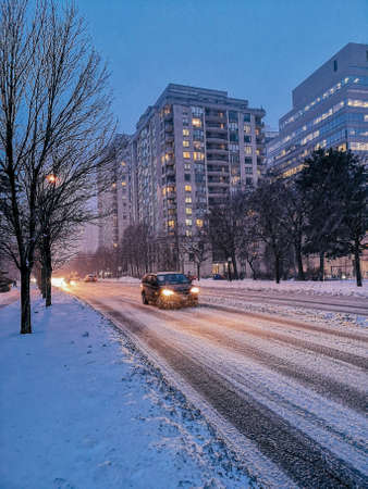 Scenic view landscape of outdoor winter city town Toronto at late evening night. Buildings, houses, trees, roads and streets covered with snow. Heavy snowstorm natural disaster cataclysm.の写真素材