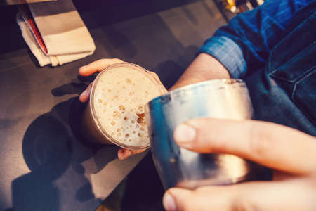 Closeup of barista hands making cold iced coffee cappuccino latte. Waiter server pouring drink in plastic transparent cup. Small business and person at work concept.の写真素材