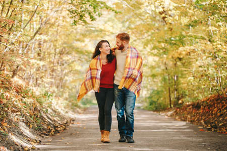 Beautiful couple man woman in love. Smiling laughing boyfriend and girlfriend wrapped in yellow...