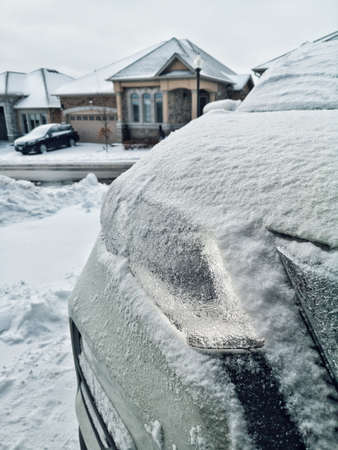 Closeup of frozen front car headlight. Bad cold weather winter problem trouble. Seasonal danger for drivers of automobile vehicles.の写真素材
