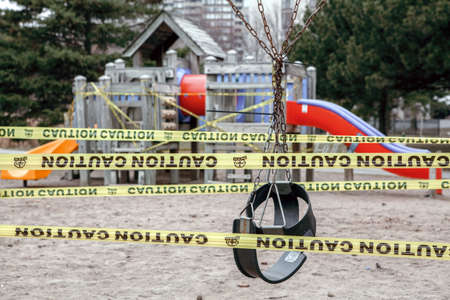 Toronto, Ontario, Canada - March 26, 2020: Closed outdoor playground. Kids play area locked with yellow caution tape to stop people gathering. Coronavirus social distance quarantine.のeditorial素材