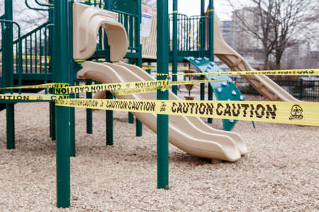 Toronto, Ontario, Canada - March 26, 2020: Closed outdoor playground. Kids play area locked with yellow caution tape to stop people gathering. Coronavirus social distance quarantine.のeditorial素材