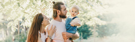 Happy smiling mother and father with baby boy in park outdoor. Family Caucasian mom and dad with son...