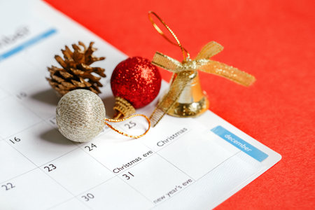 Page of planner calendar opened on December 24 Christmas holiday. Flat lay calendar with New Year or Christmas festive ornaments, toys, pine cone. Winter holidays decoration spirit mood.の写真素材