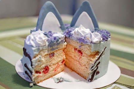 Beautiful cut of kids children birthday cake with cat ears. Funny cute sweet holiday party food for...