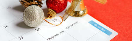 Page of planner calendar opened on December 24 Christmas holiday. Flat lay calendar with New Year or Christmas festive ornaments, toys. Winter holidays decoration. Web banner or header.の写真素材