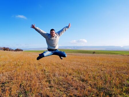 The guy jumps on a background of mountains and plantsの写真素材