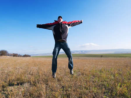 The guy jumps on a background of mountains and plantsの写真素材