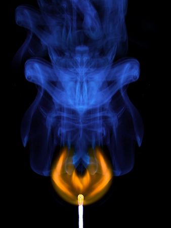 Burning match and smoke from it on a black backgroundの写真素材