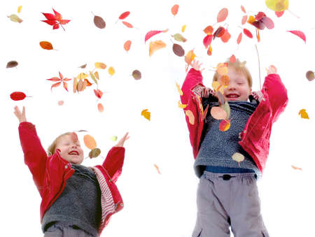 The cheerful little boy throws autumn leaves on a white background の写真素材