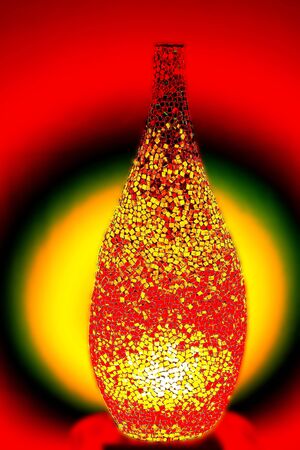 Creative lamp made by small pieces of red glass lights up the roomの写真素材