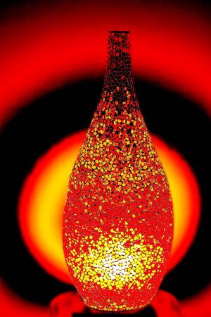 Creative lamp made by small pieces of red glass lights up the roomの写真素材