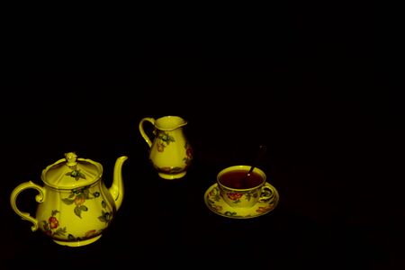 Tea time - Set for tea with ceramic teapot, cup and milk jug hand painted in flowery styleの写真素材