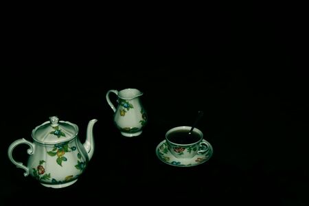 Tea time - Set for tea with ceramic teapot, cup and milk jug hand painted in flowery styleの写真素材
